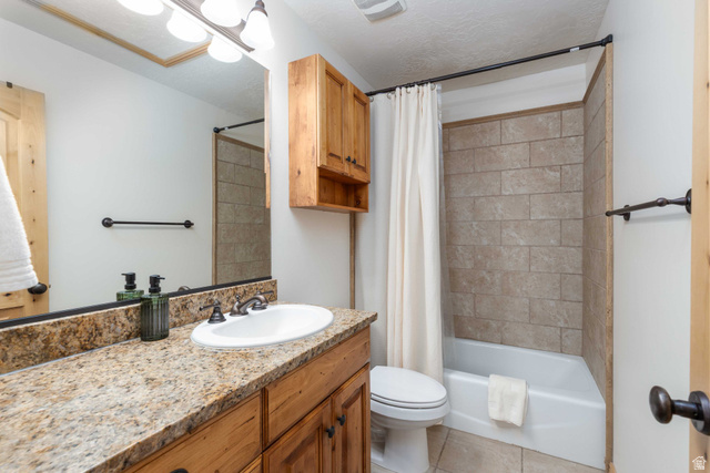 5168 Fairview Loop, Unit C604 Eden, UT 84310 - Photo 18 of 53 Bathroom with vanity, shower / bath combination with curtain, light tile patterned flooring, and a textured ceiling