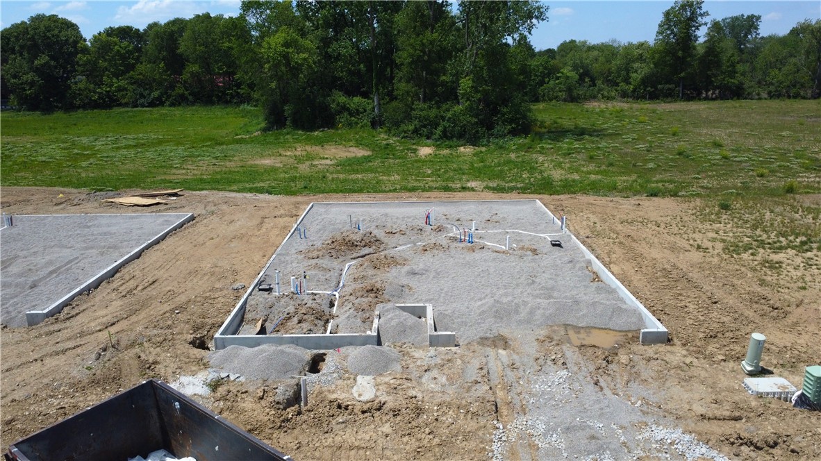 2203 Hackberry Street Springfield, OH 45505 - Photo 2 of 3 Building dreams from the ground up, this lot showcases a freshly laid concrete foundation amidst verdant surroundings.