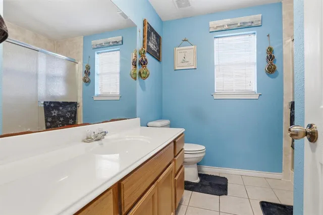 a bathroom with a sink a toilet and a window