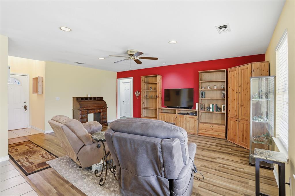 921 Calder Street Howe, TX 75459 - Photo 5 of 25 a living room with furniture a flat screen tv and a floor to ceiling window
