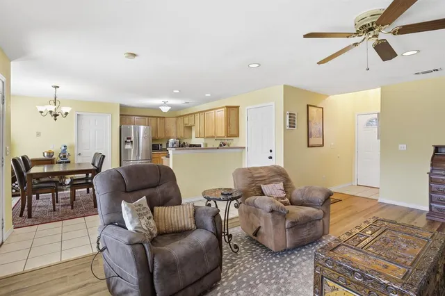 a living room with furniture and a view of kitchen