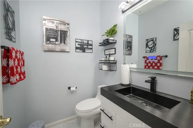 a bathroom with a sink a toilet and painting on the wall
