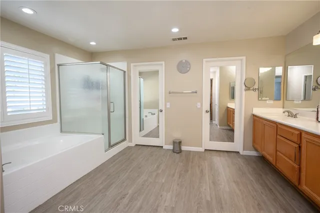 a bathroom with a tub shower vanity and a sink