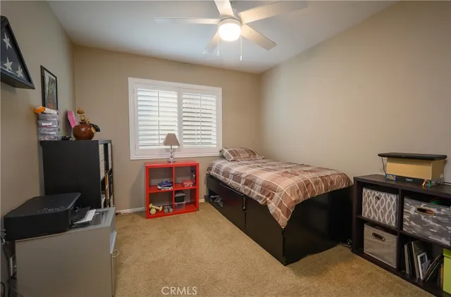 a bedroom with a bed and a flat tv screen on the dresser