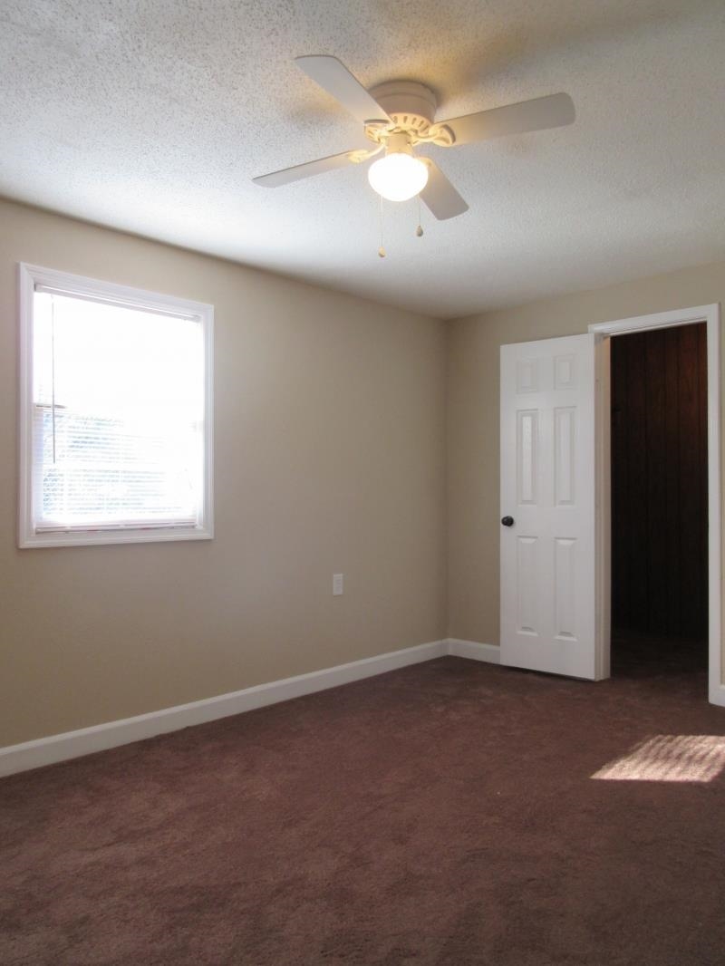 3379 Ridgecrest Street Memphis, TN 38127 - Photo 3 of 8 Spare room featuring dark colored carpet, a textured ceiling, and baseboards
