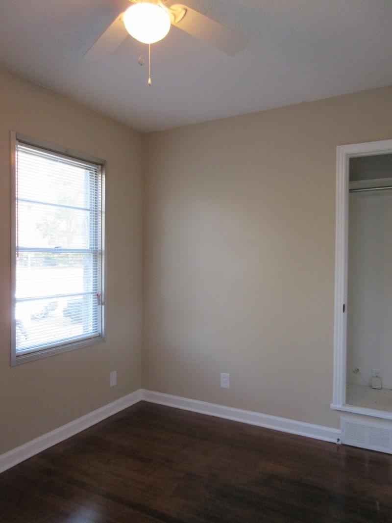 3379 Ridgecrest Street Memphis, TN 38127 - Photo 4 of 8 Empty room with a ceiling fan, dark wood finished floors, and baseboards