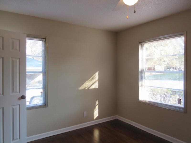 3379 Ridgecrest Street Memphis, TN 38127 - Photo 5 of 8 Unfurnished room with a ceiling fan, dark wood-style flooring, a wealth of natural light, and baseboards