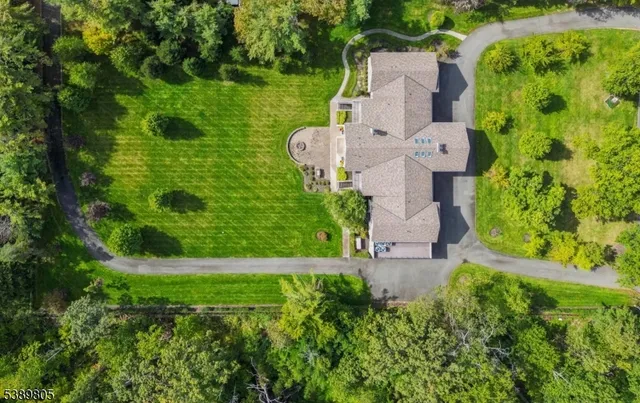 an aerial view of residential house with outdoor space and trees all around