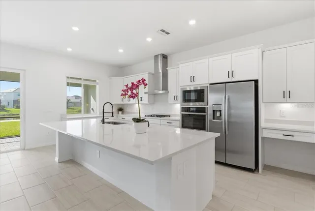 a large kitchen with kitchen island a sink stainless steel appliances and cabinets
