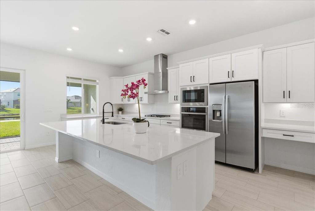 19168 Cherrystone Way Lakewood Ranch, FL 34211 - Photo 12 of 23 a large kitchen with kitchen island a sink stainless steel appliances and cabinets