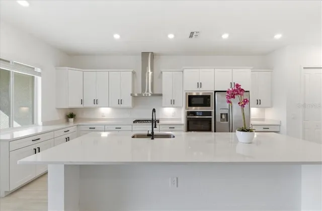 a kitchen with stainless steel appliances a sink and a refrigerator