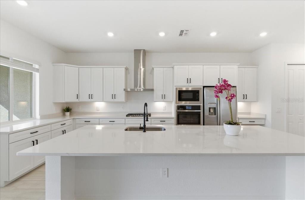 19168 Cherrystone Way Lakewood Ranch, FL 34211 - Photo 14 of 23 a kitchen with stainless steel appliances a sink and a refrigerator