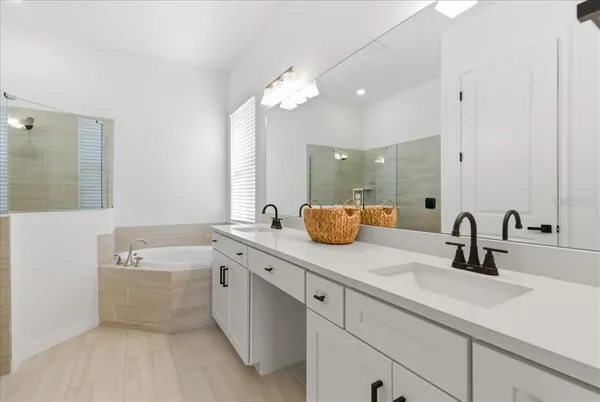 a bathroom with a sink a large mirror and a bathtub