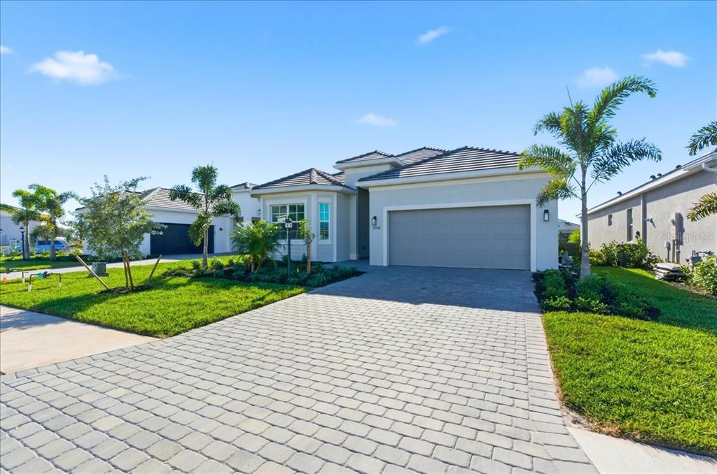 19168 Cherrystone Way Lakewood Ranch, FL 34211 - Photo 2 of 23 a front view of a house with a yard and potted plants