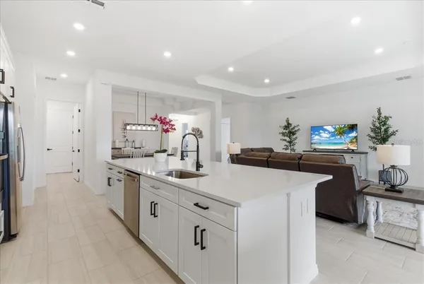a kitchen with white cabinets and sink