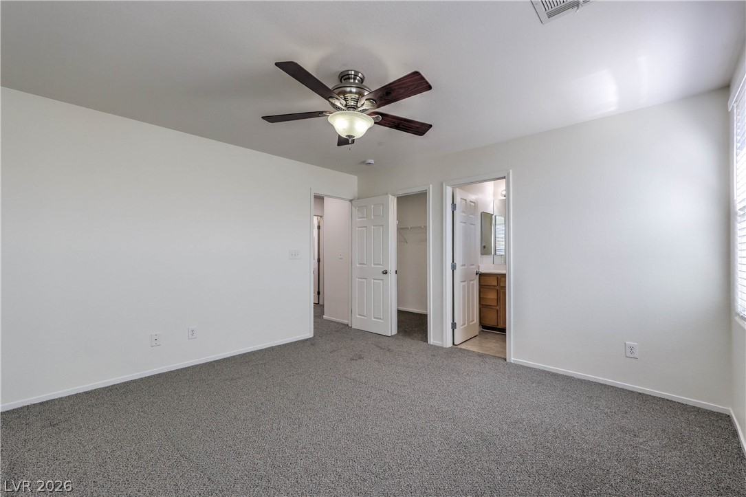 10939 Paradise Road Henderson, NV 89052 - Photo 24 of 36 Comfortable carpeting and a ceiling fan create a relaxing bedroom retreat.