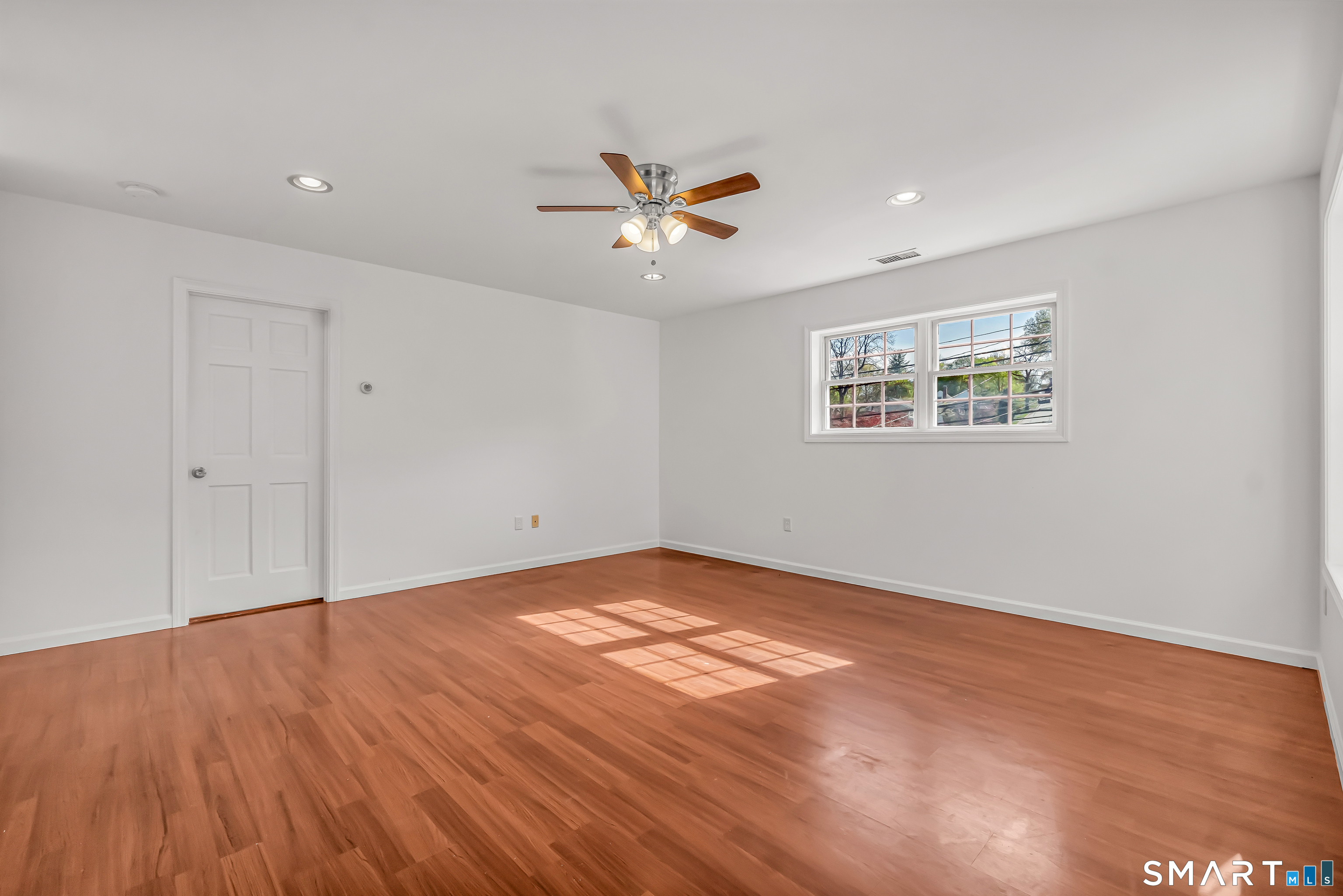 1770 Stratfield Road Fairfield, CT 06825 - Photo 28 of 40 an empty room with wooden floor and windows