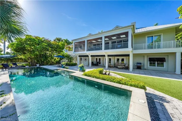 a view of a house with a yard patio and swimming pool