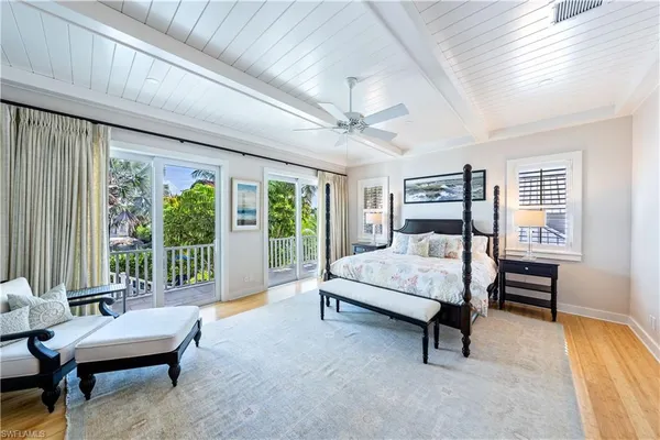 a bedroom with a bed chair and a large window