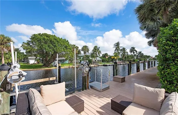 a view of a patio with couches table and chairs and potted plants
