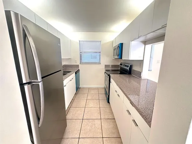 a kitchen with stainless steel appliances granite countertop a refrigerator and a sink