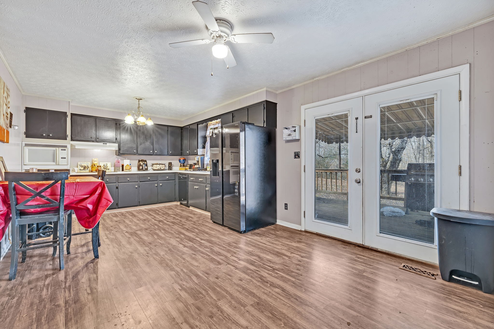 109 Cardinal Road Dickson, TN 37055 - Photo 27 of 49 a kitchen with stainless steel appliances kitchen island granite countertop a refrigerator a stove top oven a dining table and chairs with wooden floor