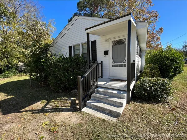 a view of a house with backyard and trees