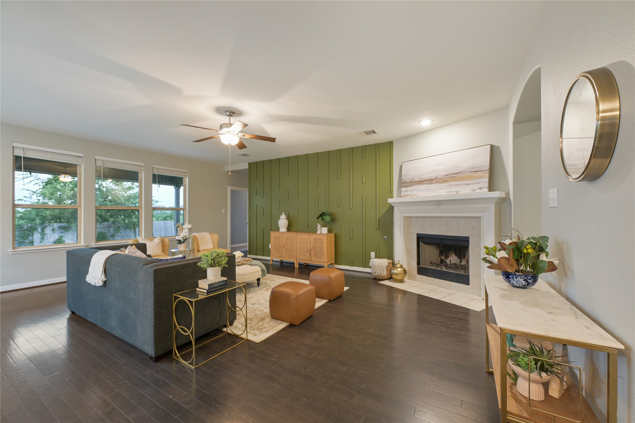 188 Nautical Loop Kyle, TX 78640 - Photo 8 of 38 Hardwood floors lead to a captivating green accent wall and a well-appointed fireplace, creating a welcoming living space.