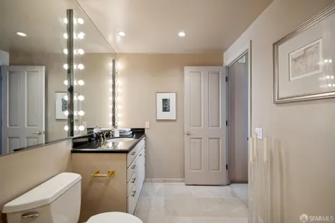a bathroom with a toilet a sink and mirror