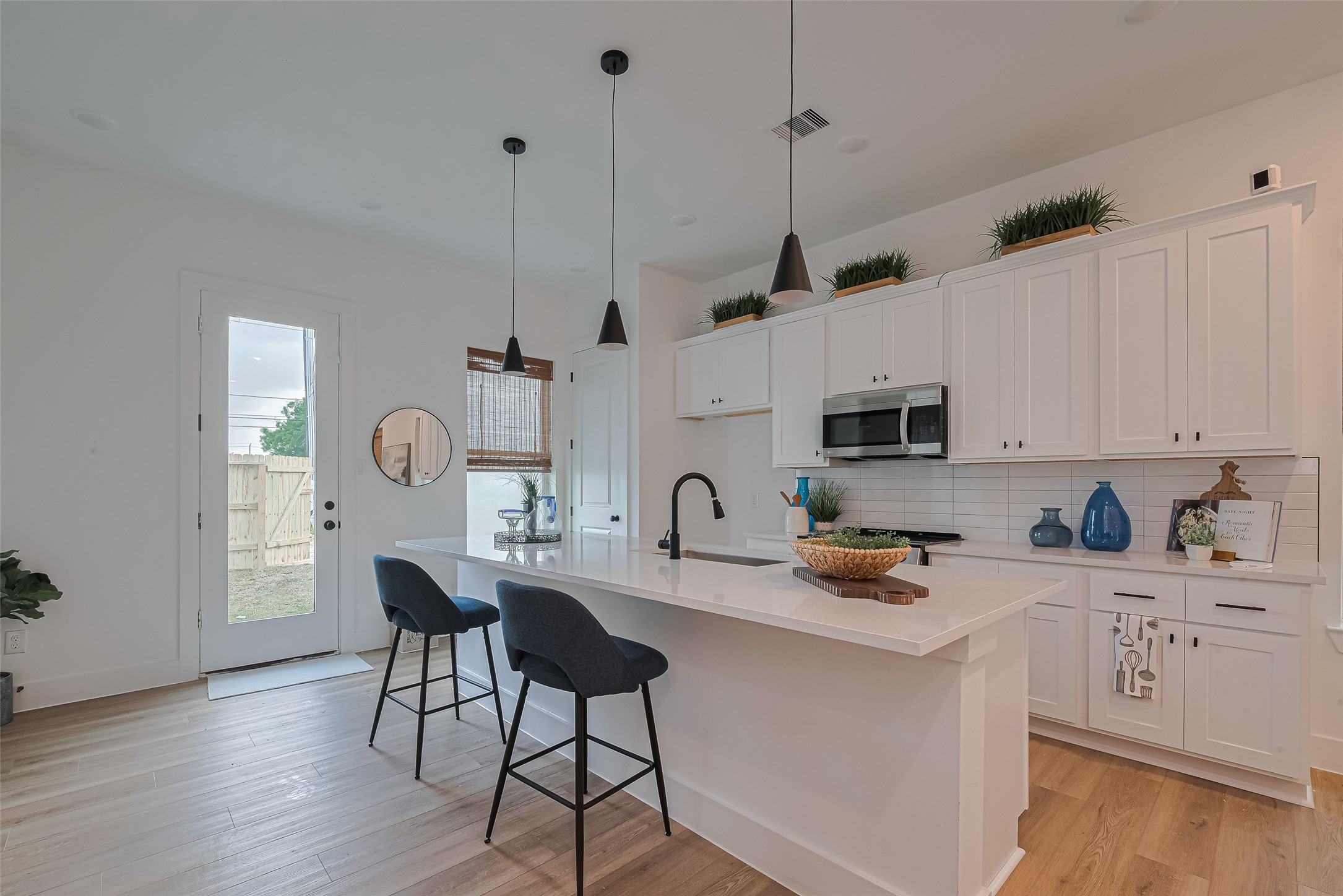 1462 Ferguson Way Houston, TX 77088 - Photo 7 of 24 a kitchen with stainless steel appliances granite countertop a stove a sink a microwave a refrigerator a dining table and chairs with wooden floor