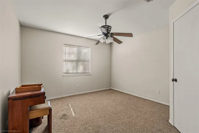 a view of room with a ceiling fan and a window