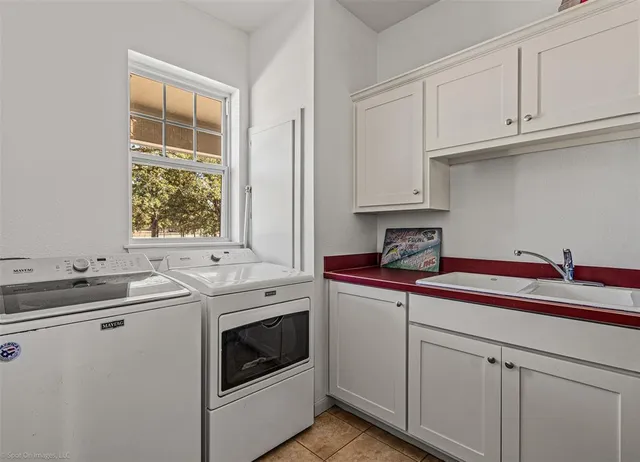 a kitchen with stainless steel appliances granite countertop white cabinets sink and window