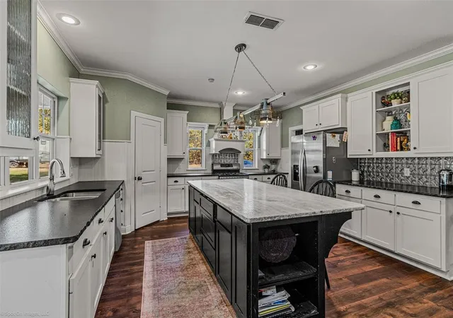 a kitchen with granite countertop a sink appliances counter top space and cabinets