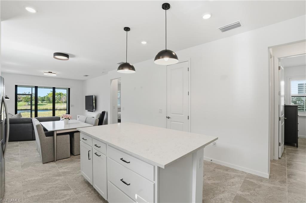 1645 Serena Avenue Naples, FL 34120 - Photo 11 of 43 a kitchen with a stove a refrigerator a sink and chairs