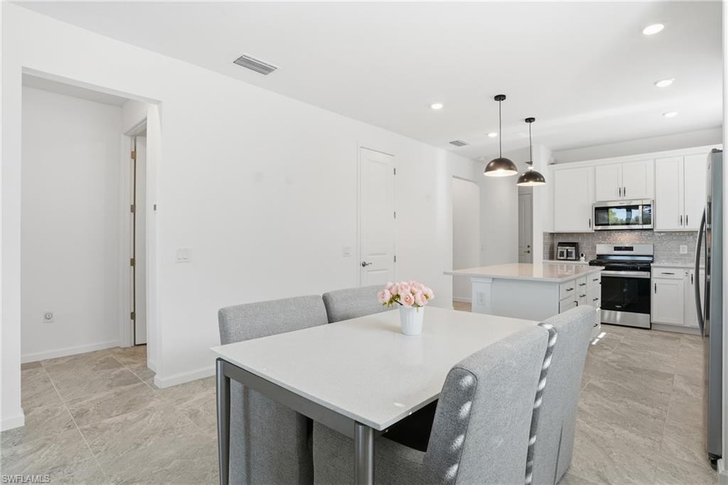 1645 Serena Avenue Naples, FL 34120 - Photo 12 of 43 a kitchen with granite countertop a sink cabinets and stainless steel appliances