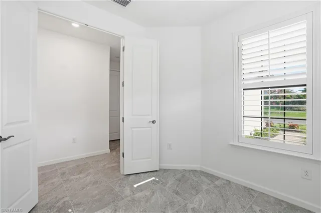 an empty room with windows and closet