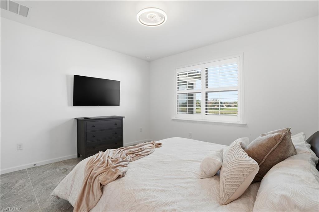 1645 Serena Avenue Naples, FL 34120 - Photo 18 of 43 a bedroom with a bed and a flat screen tv