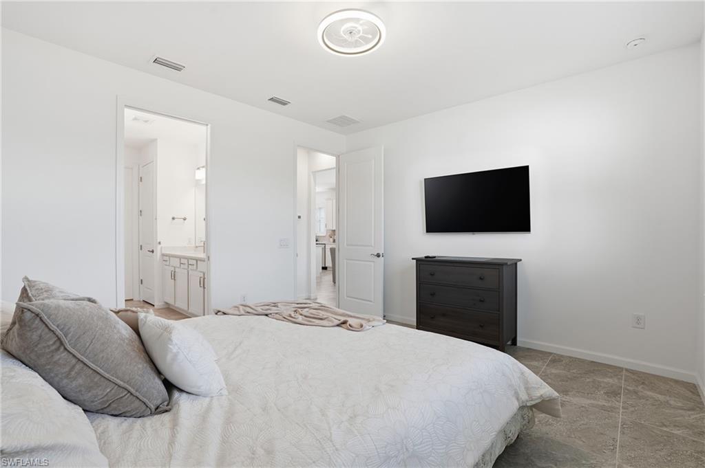 1645 Serena Avenue Naples, FL 34120 - Photo 19 of 43 a bedroom with a bed and a flat screen tv