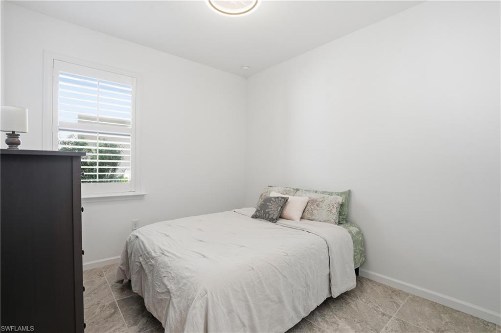 1645 Serena Avenue Naples, FL 34120 - Photo 22 of 43 a bedroom with a bed and a window