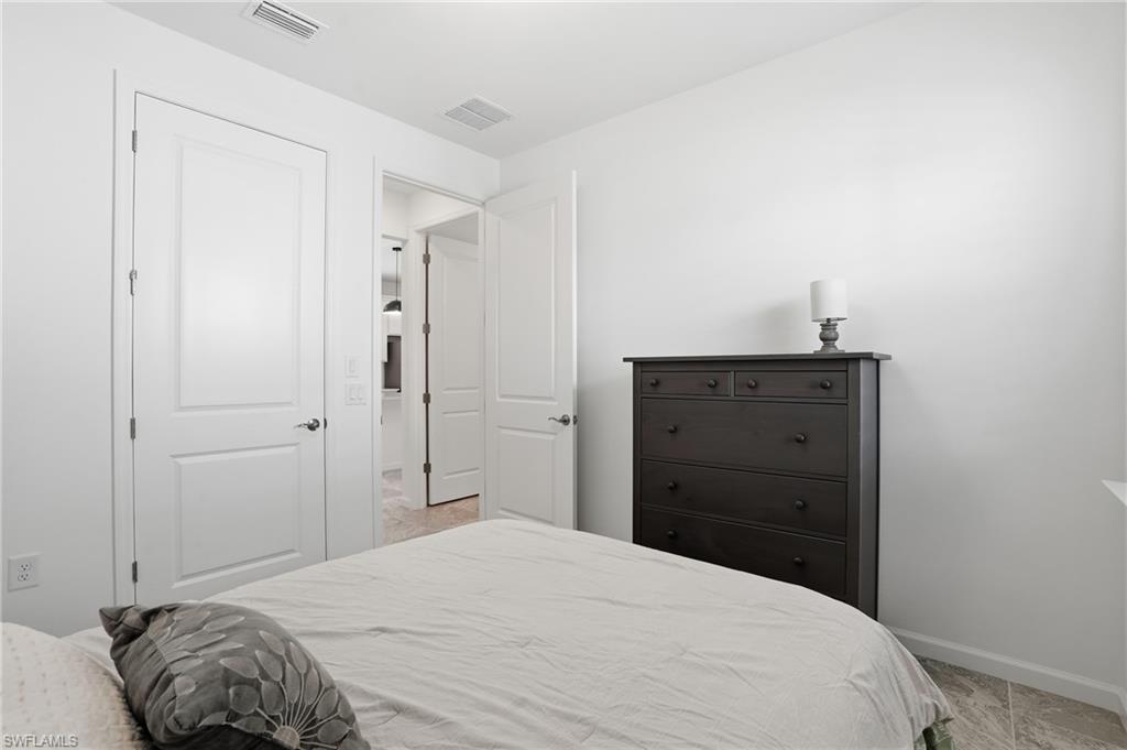 1645 Serena Avenue Naples, FL 34120 - Photo 23 of 43 a bedroom with a bed and a dresser