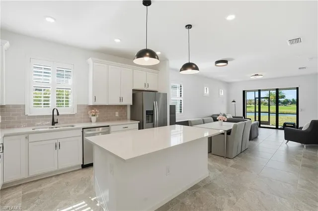 a large kitchen with kitchen island a large center island attached withe living room