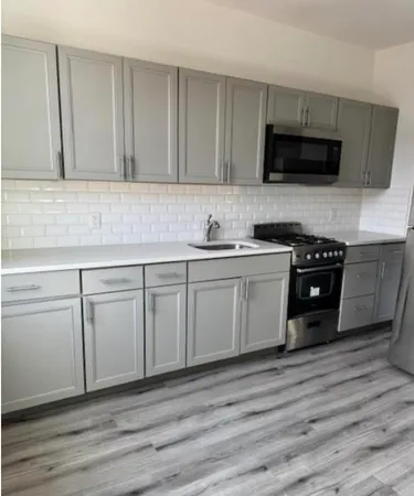 a kitchen with white cabinets stainless steel appliances and sink