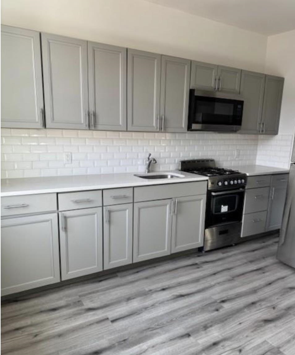 a kitchen with white cabinets stainless steel appliances and sink