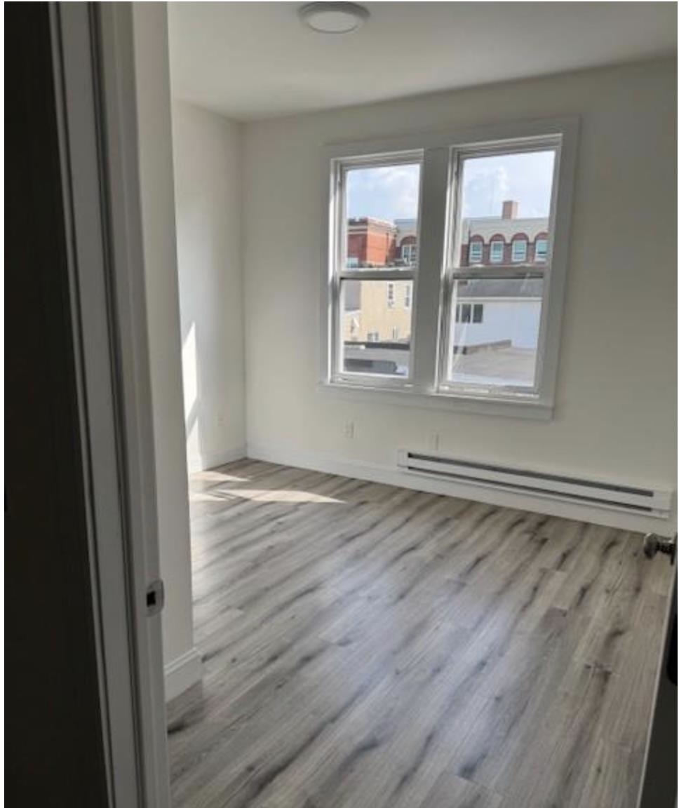 315 70th Street Guttenberg, NJ 07093 - Photo 5 of 8 a view of an empty room with wooden floor and window
