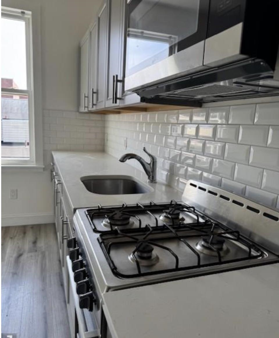 315 70th Street Guttenberg, NJ 07093 - Photo 6 of 8 a close view of a stove a sink and dishwasher in a kitchen