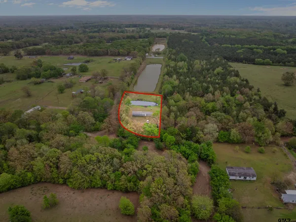 an aerial view of a house with a yard and lake view