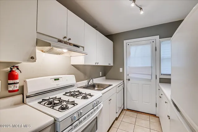 a kitchen with stainless steel appliances a stove a sink and cabinets