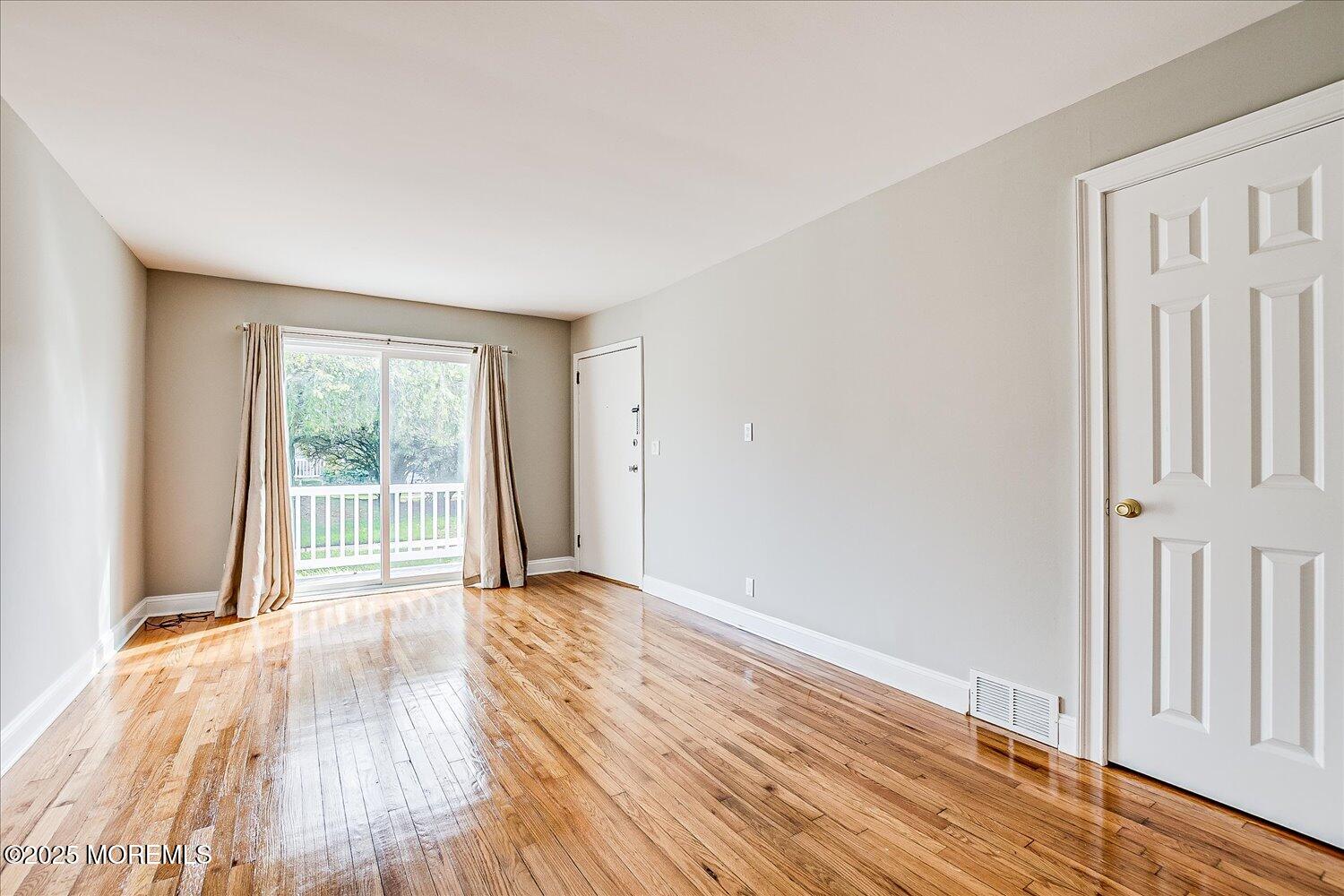 31 Cedar Avenue, Unit 11 Long Branch, NJ 07740 - Photo 5 of 19 a view of an empty room with wooden floor and a window