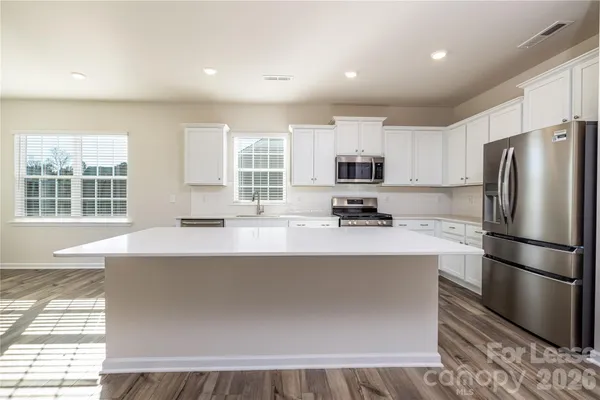 a kitchen with stainless steel appliances a refrigerator sink and microwave