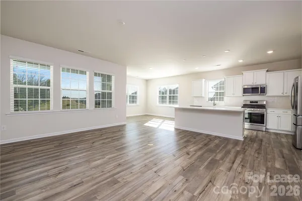 a view of kitchen with wooden floors and refrigerator